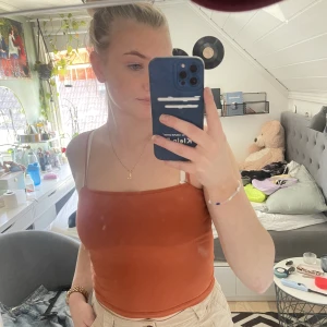 Orange/brun topp - En vanlig orange/brun topp som har ett extra tyglager över bysten så man behöver inte nödvändigtvis ha BH under. 