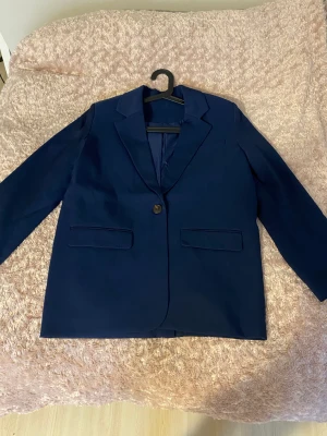 Marinblå oversized kavaj från NA-KD - Beställde den här för nån månad sen men har aldrig kommit till användning. Endast testad så den är i nyskick. Det enda är att jag redan har slitit av prislappen. Den är i storlek 34 men passar om du är en 36 också då den är oversized:) Skriv vid intresse!