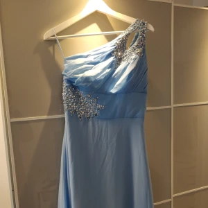 Blå balklänning - Lång, one-shoulder balklänning som är superbra i längden på mig som är 160! Köpt på loppis men säljer då den inte riktigt passade. Det är tre små fläckar som knappt syns, kan skicka bild! Står ej storlek men passar nog 36, 38, b-c kupa!❤️