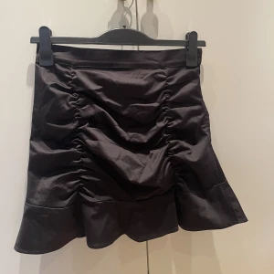 Kjol - Svart kort kjol från NA-KD i strl 38. Skick: oanvänd