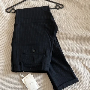 Les Deux Como Pinstripe Suit Pants  - Oanvända Les Deux byxor, med lappen kvar, i storlek 28/30. Navy med vita stripes, nypris 1099kr.