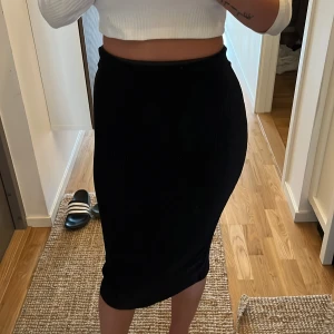 SVART VELOUR KJOL - Säljer denna fina svarta kjolen som har en slits baktill samt är i mjukt velour tyg. Tyget är även ribbat. Storlek XS, passar även S, är stretch. Nyskick. Säljer för 200 kr. Köparen står för frakten!