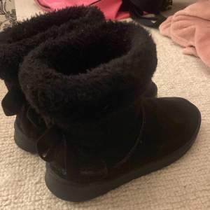 Superfina fake uggs med fluff högst upp och rosetter där bak i bra skick 