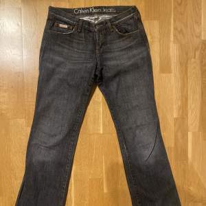 Superfina jeans med låg midja och utsvängda ben fran Calvin Klein. Jätte snygga fickor med paljetter/ glitter. Svarta/gråa💗Skriv för fler bilder💗Storlek W: 28 🫶Skriv för mått!