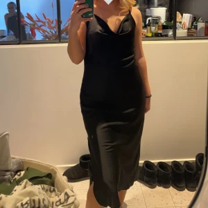 Svart satin klänning  - Klänning från en borttagen butik i Kista galleria. Använd 2 gånger den är som ny. Banden vid axlarna är justerbara. Köpt för 500 kr 