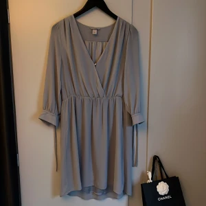 Klänning  - Jättesöt klänning i svagt duvblått. 3/4 ärm med band. 