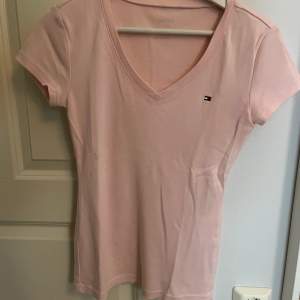 V ringad T-shirt från Tommy Hilfiger i Rosa färg.  Mycket bra skick, Använd 1 gång. Som ny Ord pris 380kr