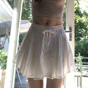 En fin vit kjol med volanger som är perfekt till sommaren. Köptes förra året så är i bra skick. Säljer då den tyvärr är förliten för mig. Kontakta för fler bilder och det finns en liten fläck som knappt syns. Kjolen har även inbyggda shorts och fickor. 