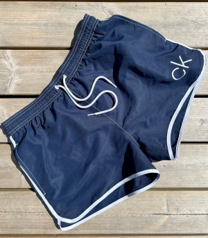 Calvin Klein NYC runner badshorts - Badshorts från Calvin Klein.  Modell NYC runner  Knappt använda. Marinblå. 
