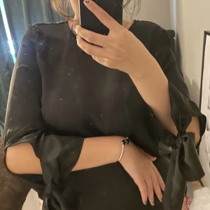 Sidenblus med knyte - Svart sidenblus från Gina Tricot i storlek 34 med knytning i armarna, blusen är ny och har därför inga defekter. Ord pris 299kr