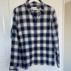 Skjorta från Sandro Paris - Skjorta från Sandro Paris, köpt för några år sen men bara använd 2 gånger pga lite för liten. Nyskick. Storlek M. Jag är 187 cm, 78 kg. Köptes för 350 euro men finns en väldigt lik ny modell i rött att köpa för 195, som visas på sista bilden