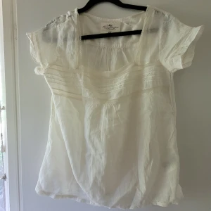 Blus tunn cremefärgad stl.38 - Söt cremefärgad/vit tunn blus m spets, sydda veck och hålsöm  fram.. Superfin med vitt linne under! Perfekt till  midsommar.