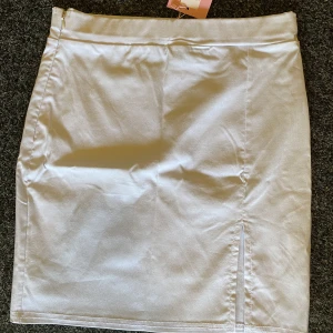 Tajt kort kjol med slits - Tajt kort kjol med slits. Prislappen kvar, aldrig använd.