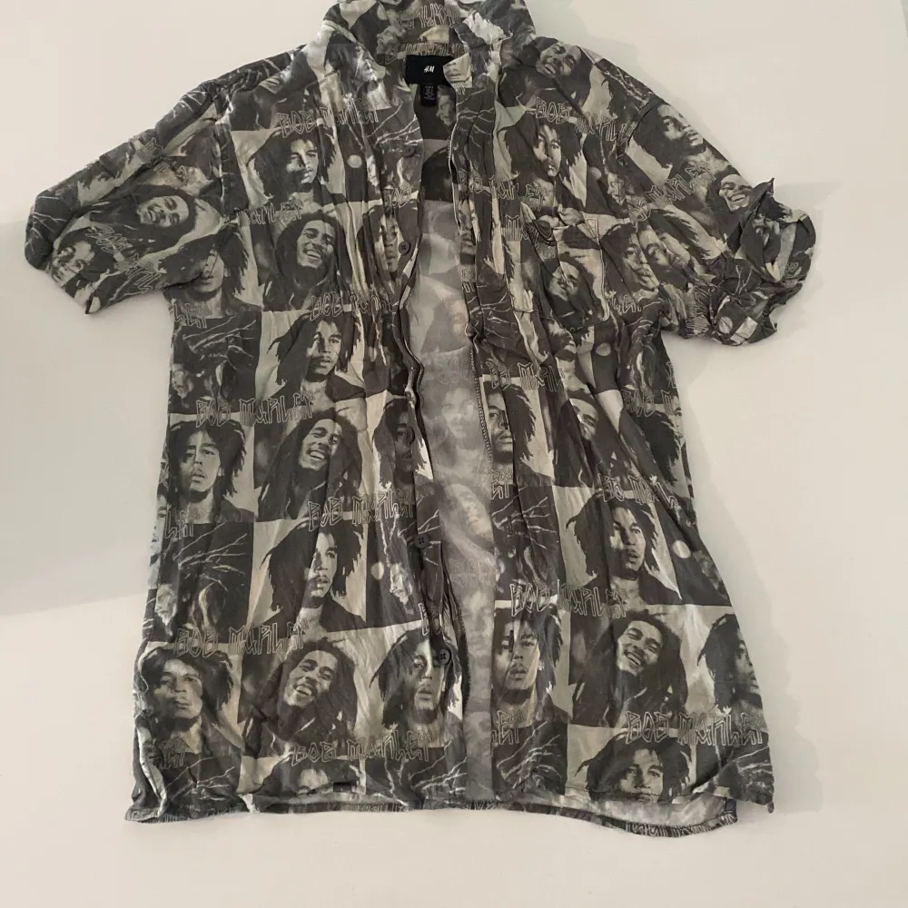 Skjorta i storlek S med coolt Bob Marley tryck! Köptes för ca 200kr på H&M, säljer då den är för liten för min kille. (Har tyvärr inget strykjärn hemma annars hade jag självklart strykt den😩) . Skjortor.