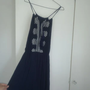 Superfin sommarklänning - Klänningen är ganska lång och på mig som är runt 160 cm lång, är den ungefär ankel-lång. Axelbanden ställer man själv genom att knyta klänningen med snörena fram.