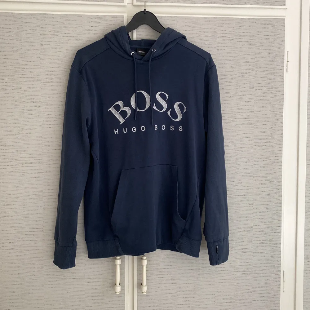 Hugo Boss hoodie storlek L men passar även M. Mörkblå/Navy blue med vit text. Gott skick, endast nåt år gammal och den är knappt använd.  Beställt på CareOfCarl för ca 1600kr. Hoodies.