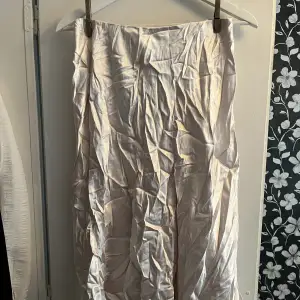 Ljusrosa kjol i siden med slit fram. Köpt från sellpy men aldrig använd sen dess. Storlek S/M så passar båda två.  