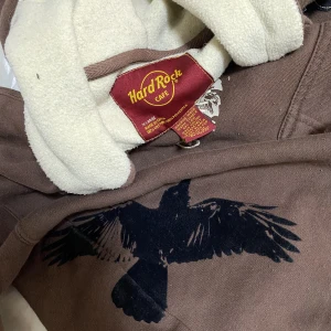 Hard rock café hoodie - Unik Hard Rock Café ziphoodie, i luvan finns det ett filmhål samt lite slitage runt tumhåken tröjan har men inget är så märkbart. 