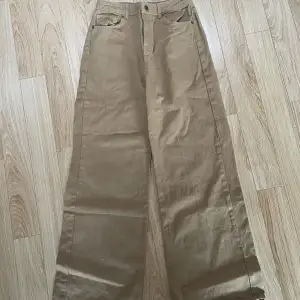 Mörkgula/gulbruna högmidjade jeans. Wide leg.