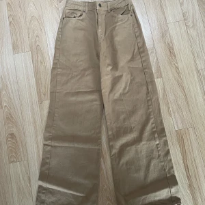 Gula jeans - Mörkgula/gulbruna högmidjade jeans. Wide leg.