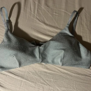 Oanvänd bikiniöverdel  - Glittrig bikiniöverdel, ej använd men lappar finns inte kvar. Trosorna kommer säljas i en annan annons men man kan köpa dem tillsammans för 100kr eller var för sig för 75kr styck