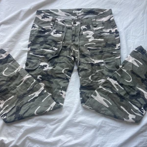 Cargo byxor  - Skit snygga lågmidjade Camoflage byxor som jag köpte här på Plick men jag tyckte inte dom passa så bra så jag säljer dom vidare. Innerbenslängden är 81 cm, midja 88cm. Skriv om ni vill ha fler bilder eller har några frågor💕(sista bilden är lånad)