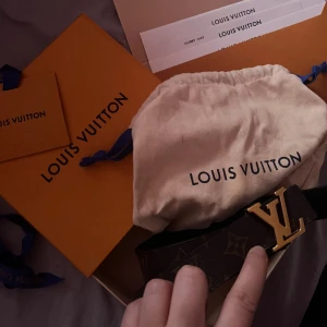 Louis Vuitton bälte  - Lv diverse bälte som kan skiftas mellan svart läder och brunt läder med guld LV detalj. Den är i storlek 80/32. Jag har kartongen och påsar som kommer med, har ett tackkort och nogonlunda kvitto då det var en gåva men artikelnummer/referens står på bältet