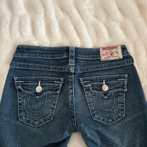 TRUE RELIGION LÅG MIDJADE JEANS - Sjukt snygga och mycket låg midjade jeans i storlek 26. Den är lite flair. Har inte använt länge fast köpte jeansen av en annan säljare. Mycket Bra skick. Materialet är väldigt bekväm. Ställ gärna frågor, köparen står för frakten. 🙃