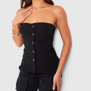 Tubtopp - Svart tubtopp med knappar passar bra till festliga tillfällen. Säljer pga att den är för liten på mig, använt endast en gång.