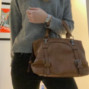 Handväska - Brun handväska som medföljer med ett långt band också!! Vet ej märker men den är i väldigt fint skick 🥰