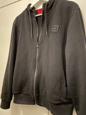 Hugo boss full zip - En stilren Hugo boss ziphoddie med luva, skicket på tröjan skulle jag säga är 10/10. Använd ett fåtal gånger och inga skavanker på den,  Kom me ett pris så diskuterar vi i pm Mvh, Sigge 