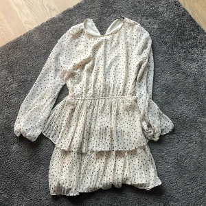Klänning med prickar på - Jättefin vit klänning med svarta prickar på som slutar precis innan knäna. Från Gina tricot.