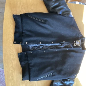 Baseballjacka - Säljer nu denna Baseball jacka köpt för ca 2 år sedan för 1500 på baseball jackor Sverige då den blivit för stor. Skinn ärmar, vilket består av äkta läder. Den är i använt skick men inga skador eller liknande. Kan mötas upp och frakta. Mvh Axel