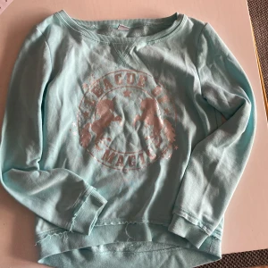 Tjocktröja  - Fin tjocktröja med enhörningstryck i storlek 146/152. Det ”slitna” vid tröjans mud är köpt och meningen så.  Inget slitage eller fläckar. Rökfritt-och djurfritt.