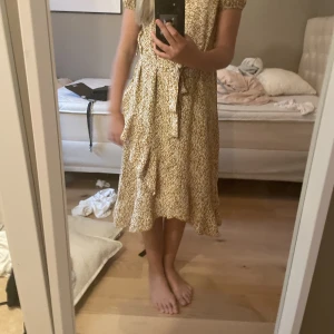 Senapsgul klänning  - En tun klänning med blommor 