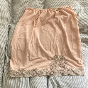 Pastellkjol - Söt kjol som funkar som underkjol eller kjol över jeans. Den är lite genomskinlig och en ljus aprikosfärg. Skönt material med stretchig midja🌺stl ej angiven men passar mig (stl 36). 