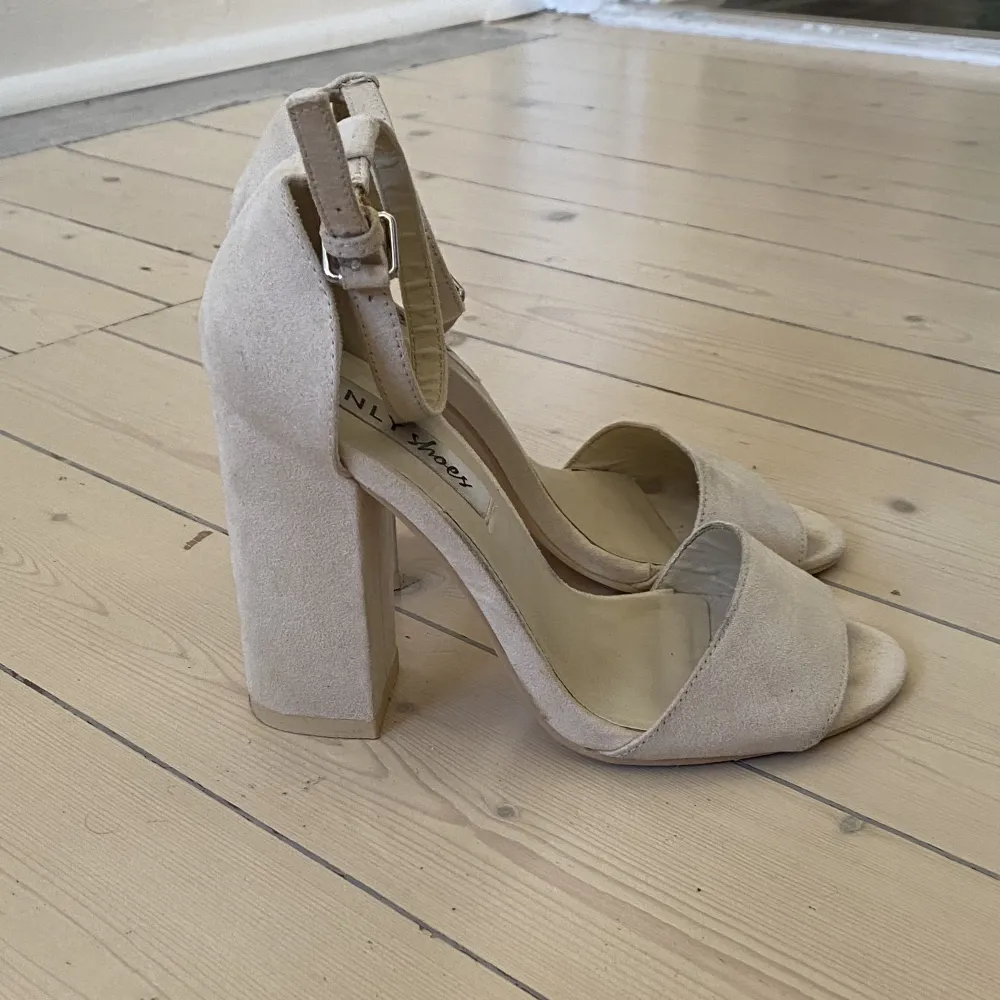 Vita klackar med 8 cm klackhöjd från Nelly. Modellen heter ”mid block heel sandal”, finns några tecken på användning därav den låga prissättningen. Skor.