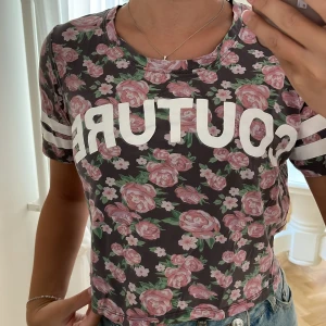 Blommig T-shirt  - Blommig T-shirt med vit text ”Couture” på. Superskön! 