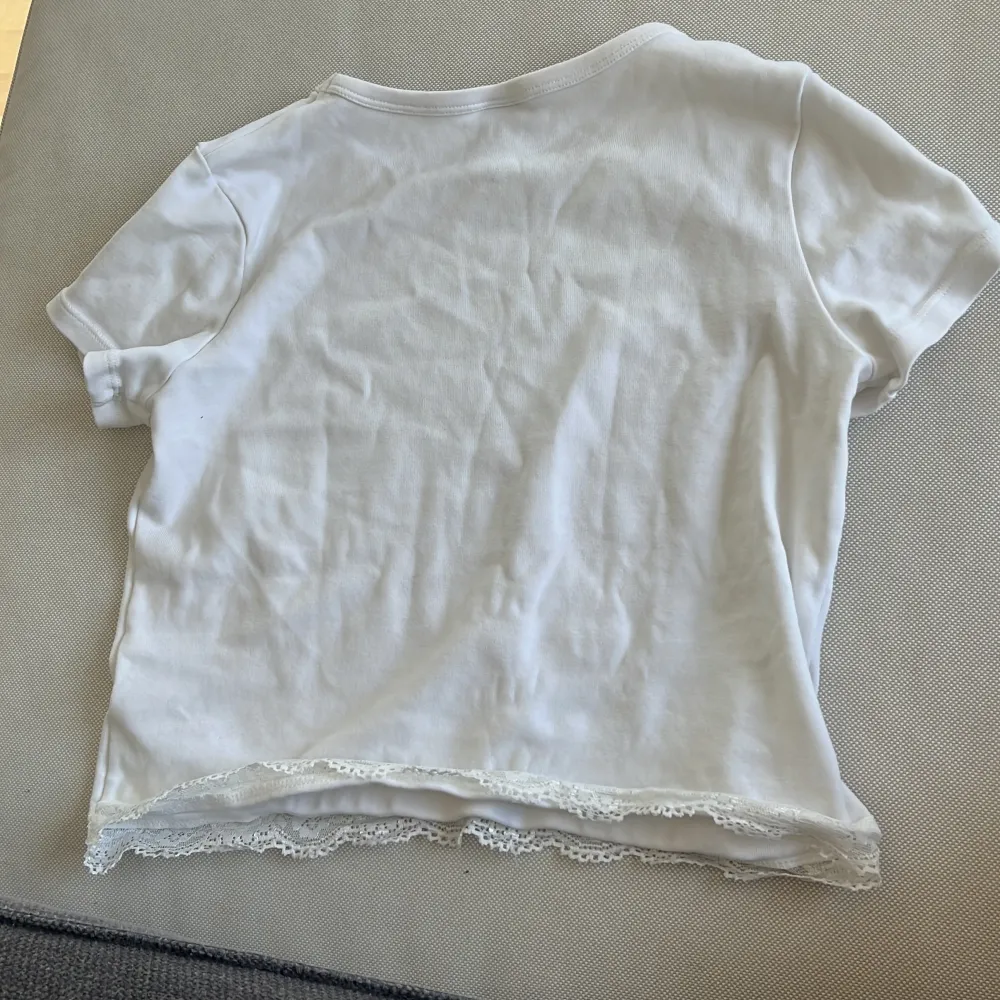 En vit topp med spets längst ner från lindex. Skriv för mer info💗. T-shirts.