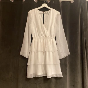 Studentklänning  - Vit studentklänning. Använd 1 gång. Har små fläckar vid ärmerna från studenten men ej jätre synliga, och på baksidan.