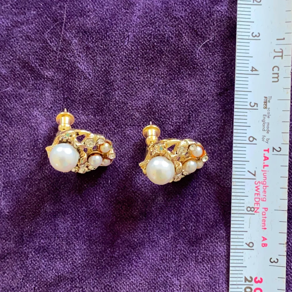 Små guldfärgade örhängen med pärlor  Okänt material . Accessoarer.