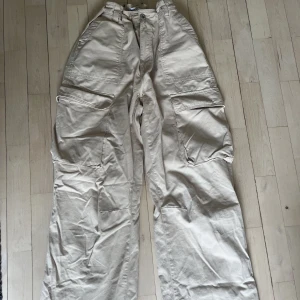 Beige cargo byxor  - Beige cargo byxor från bershka. Storlek 40 men lagt in resårband så man kan även ha dem om man har storlek 36/38. Jättesnygga på!