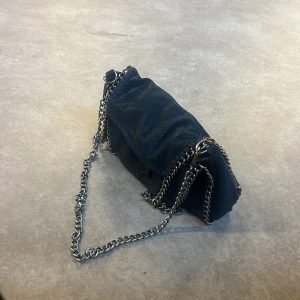 Stella McCartney liknande väska  - Hej! Säljer nu min marinblåa väska som liknar Stella McCartney väskorna. Vill helst byta mot någon annan. Finns band med. Köpt på Plick så vet inte vart den är ifrån 🫶🏼