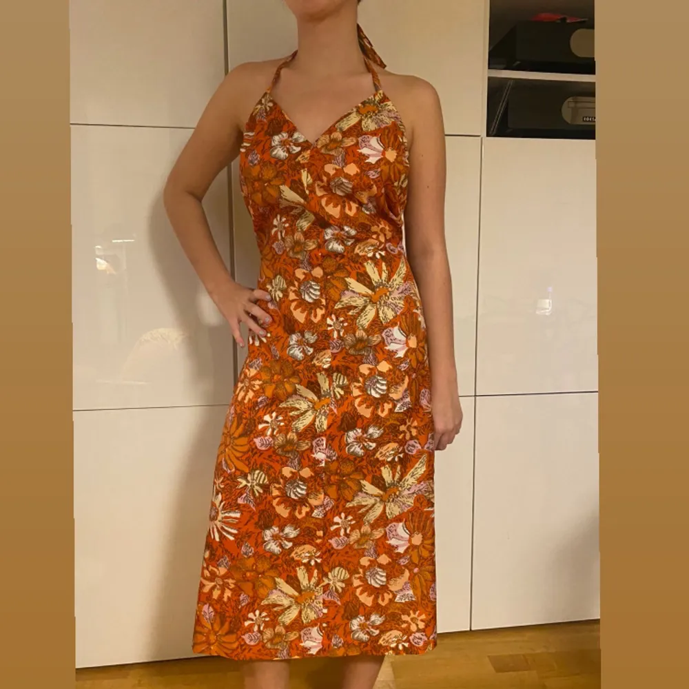 Orange klänning med öppen rygg och blommigt mönster! Funkar för sommar men även höst pga färgen🦀🪐✨. Klänningar.