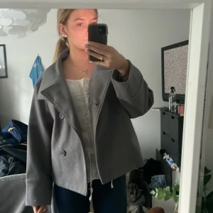 Grå kappa - Säljer denna gråa kappan från gina tricot eftersom jag aldrog andvänt den