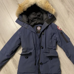 Canada goose jacka - Mörkblå Canada goose Montebello   Använd två vintrar, skada på ärmen (se bild) Äkta päls runt luvan 