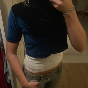 Plysch topp - Jättefin topp i marinblå plysch vilket gör att den ”glittrar” lite grann. Den har polokrage med korta ärmar💕jättebra skick aldrig använd. Finns tyvärr inga lappar kvar på toppen men passar xs/s