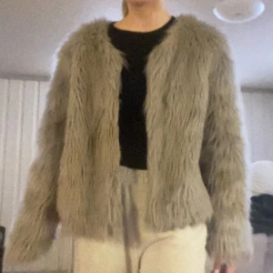 Päls jacka/kappa - Färgen syns bäst på första bilden!Coolaste pälsjackan (fake päls) Liten i storleken sitter som en m/s Ljusgrå Inga defekter förutom två fläckar på ärmarna som knappt syns som var där när jag köpte den (går förmodligen bort i tvätten)