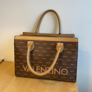 Valentino väska  - Väskan har små slitningar men inget som inte går att fixa! Den är rymlig och har flera fickor inuti. Kan behöva en tvätt på insidan. Nypris: runt 2000