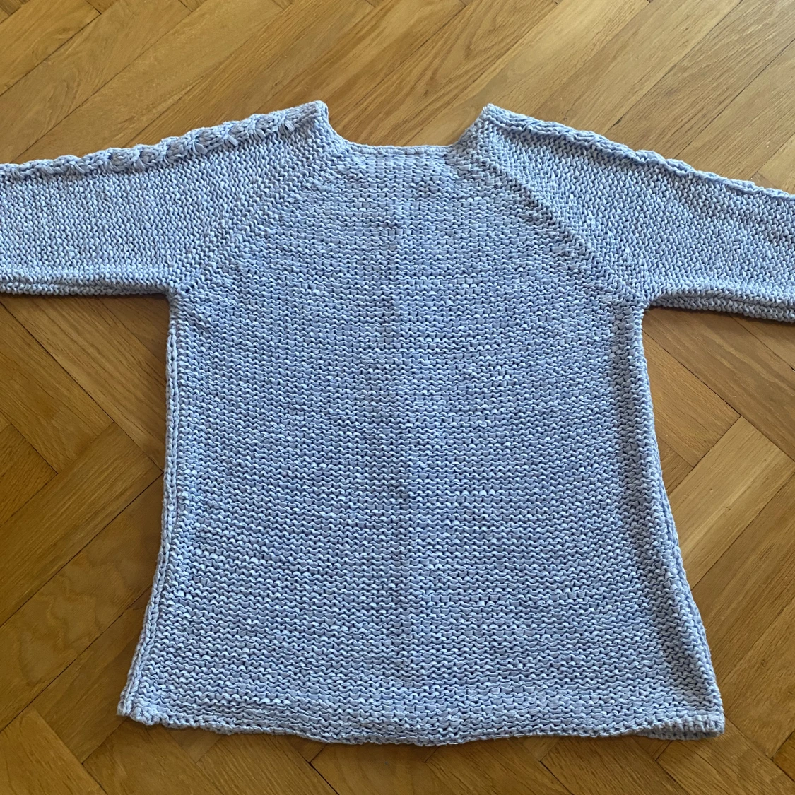 Lös stickad ljus blå tröja med flätor på armarna och i mitten partiet - 91